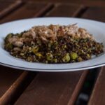 Piatto di lenticchie e quinoa con verdure fresche, ideale per una cena leggera e gustosa.