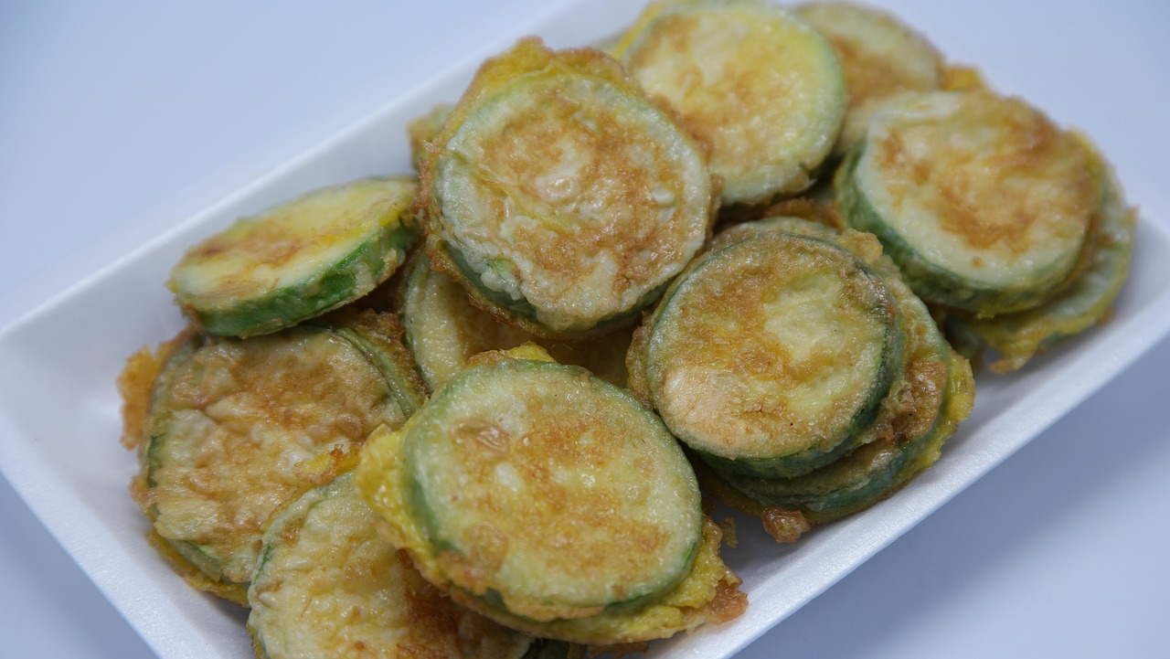 Frittelle dorate di zucchine e formaggio su un piatto, pronte da gustare.