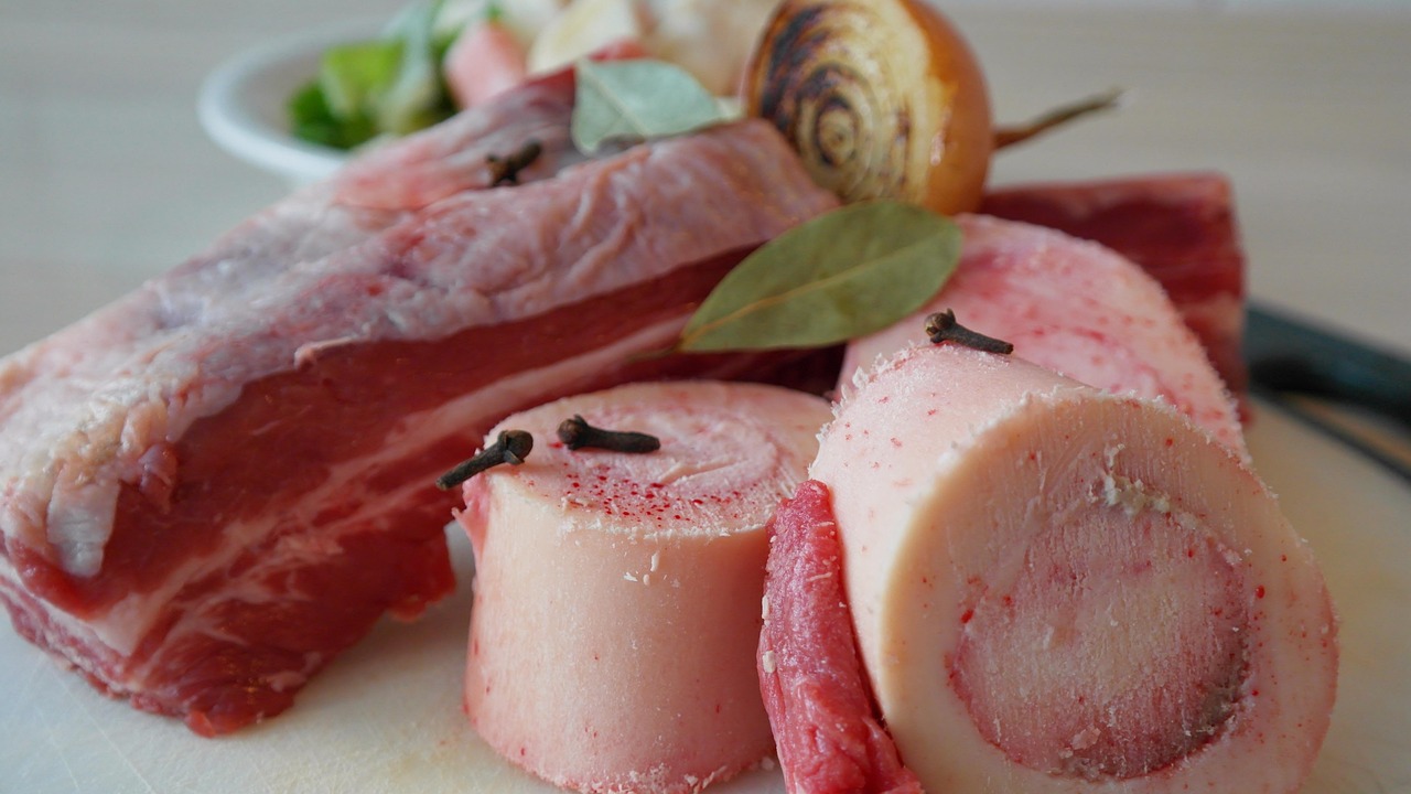 Brodo di carne fatto in casa con ingredienti freschi in una pentola sul fuoco.