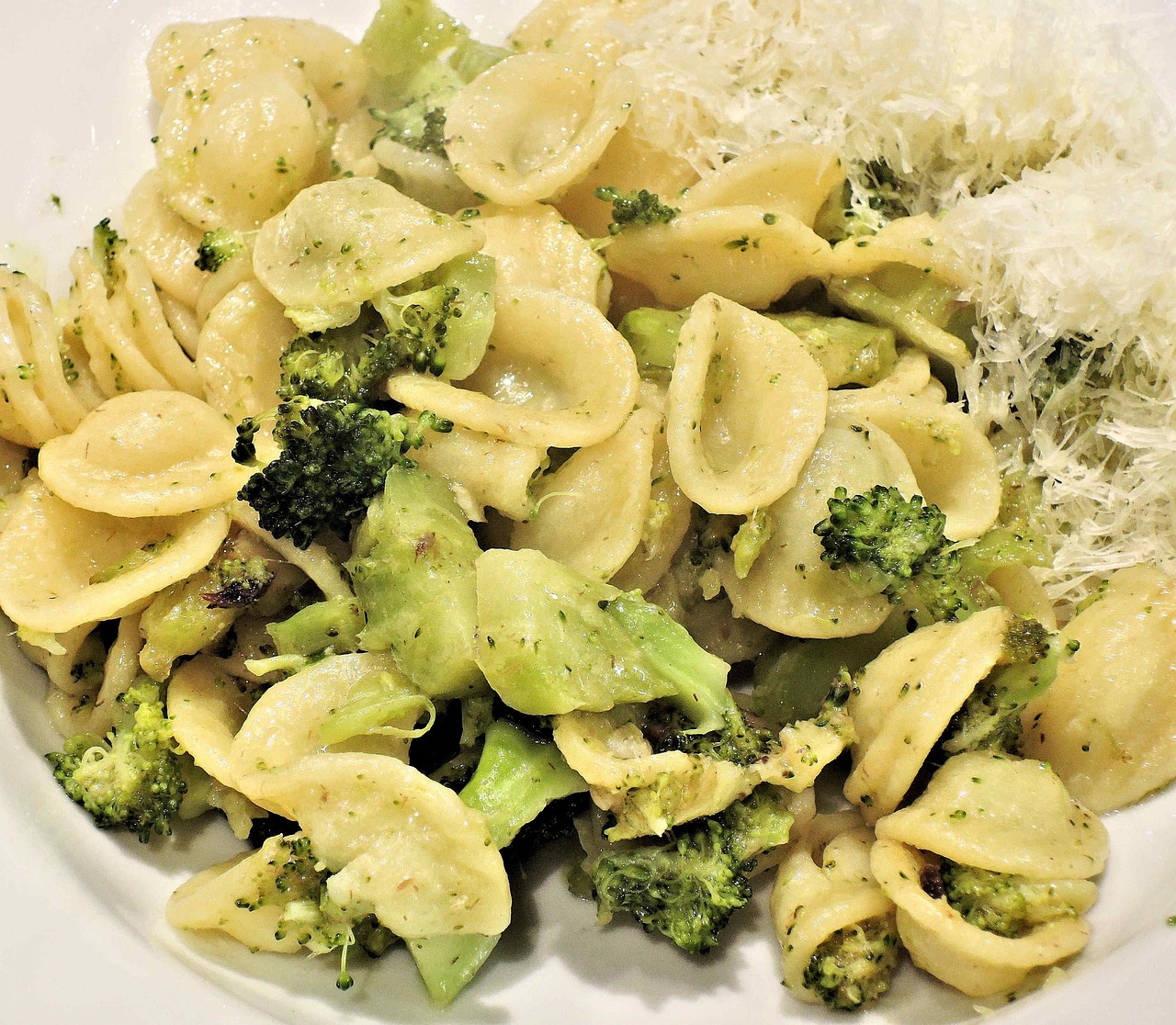 Pasta con broccoli e salsiccia, piatto gustoso e colorato, servito in un piatto bianco.