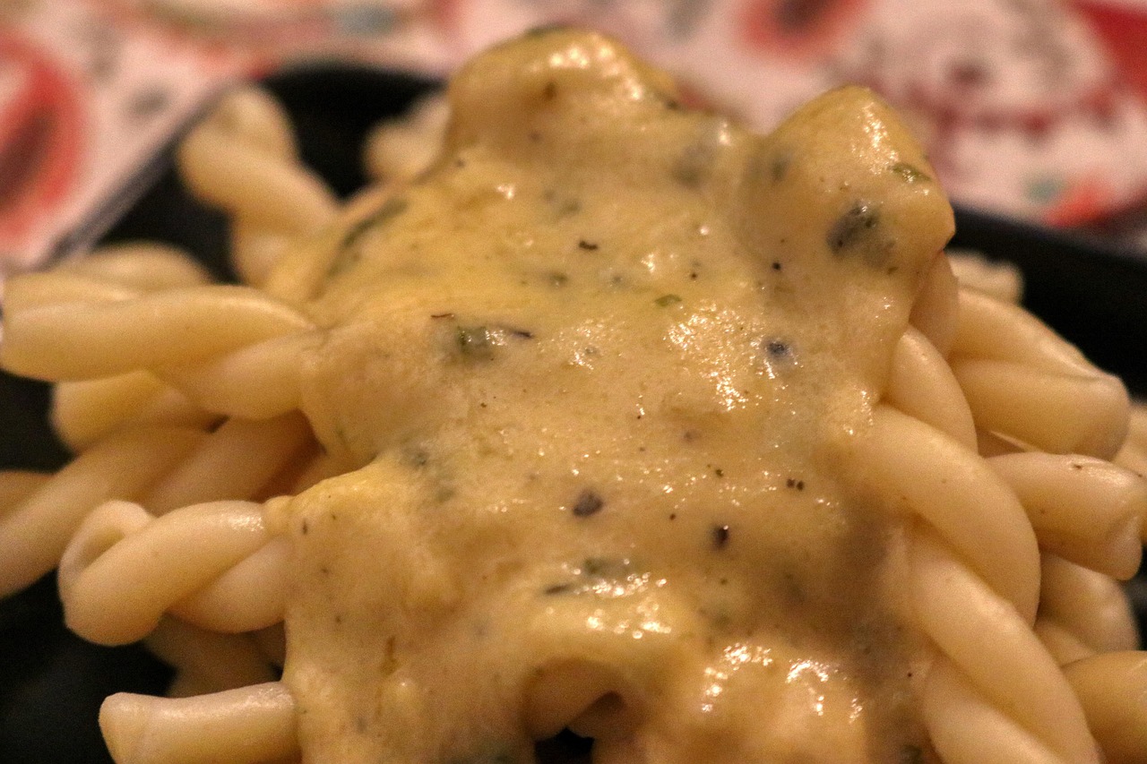Pasta e patate cremosa servita in un piatto, con una spolverata di formaggio e prezzemolo fresco.