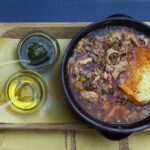 Ciotola di ribollita toscana fumante, ricca di verdure e pane raffermo.