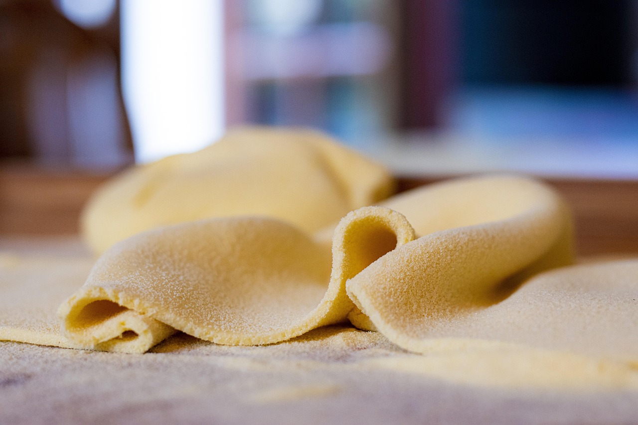 Tortelli di zucca mantovani serviti su un piatto blu, decorati con burro fuso e salvia.