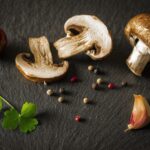 Funghi trifolati in padella con aglio, prezzemolo e olio d'oliva, pronti da servire.