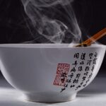 Piatto fumante di zuppa servito a tavola, simbolo di una cena calda e salutare.