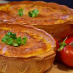 Lasagne appena assemblate pronte per il riposo prima della cottura in forno.