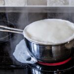 Latte riscaldato più volte in un pentolino, con vapore che si alza.