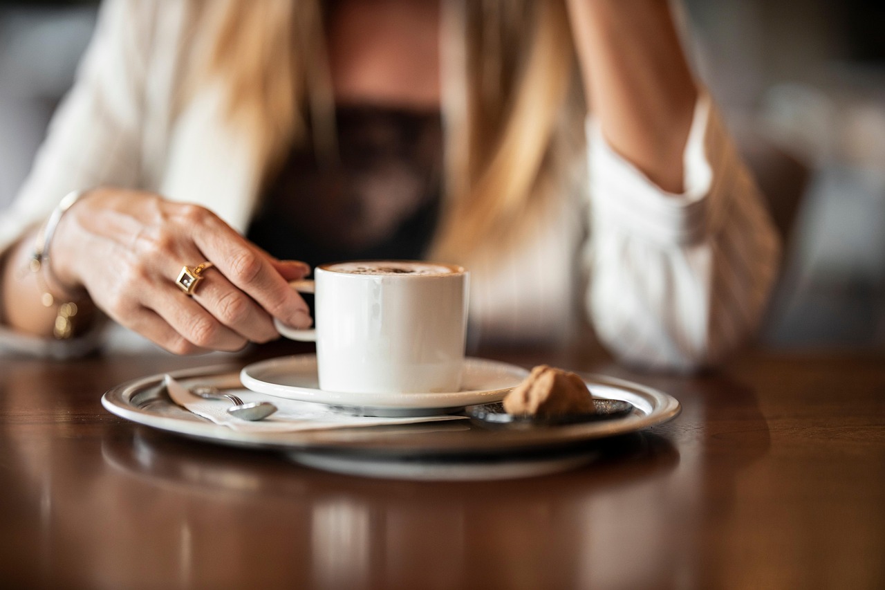 Tazza di caffè fumante su tavolo, simbolo di pausa dopo pranzo per favorire la digestione.