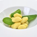 Gnocchi di spinaci e ricotta su un piano di lavoro, pronti per la cottura.