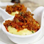 Polenta cremosa in un piatto, con un ingrediente segreto in evidenza accanto.